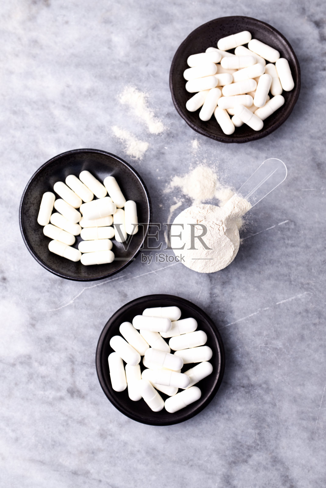 乳清蛋白,水解膠原I型,l -脯氨酸和l -賴氨酸膠囊勺。補(bǔ)充膠原蛋白的生產(chǎn)。明亮的石頭背景。直接上圖。副本的空間。